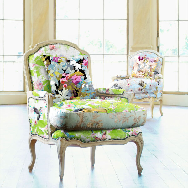 Pattern Avia, colour Spring, on chair in foreground. Avia, colour Joy, on chair in background. Pattern Flores, colour Fun, on pillow in foreground. Flores, colour Echo, on pillow in background.