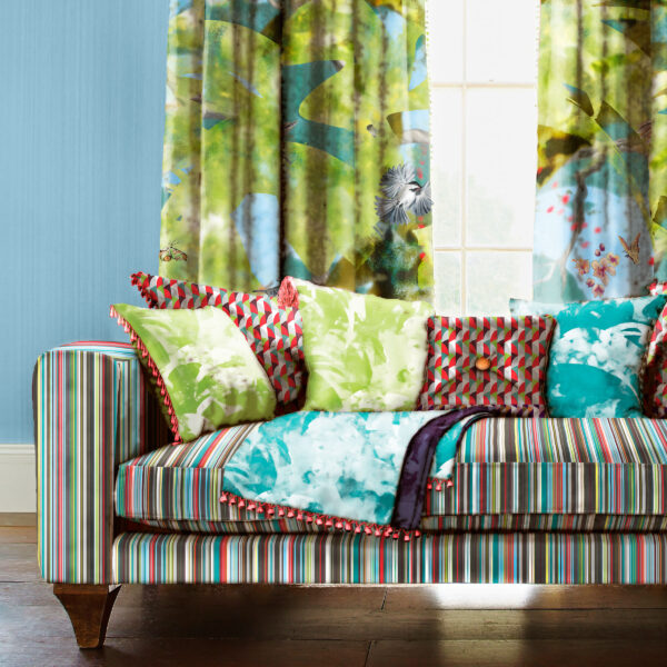 Pattern Herba, colour Tranquil, on sofa. Arbor Vitae, colour Serenity, on wall.